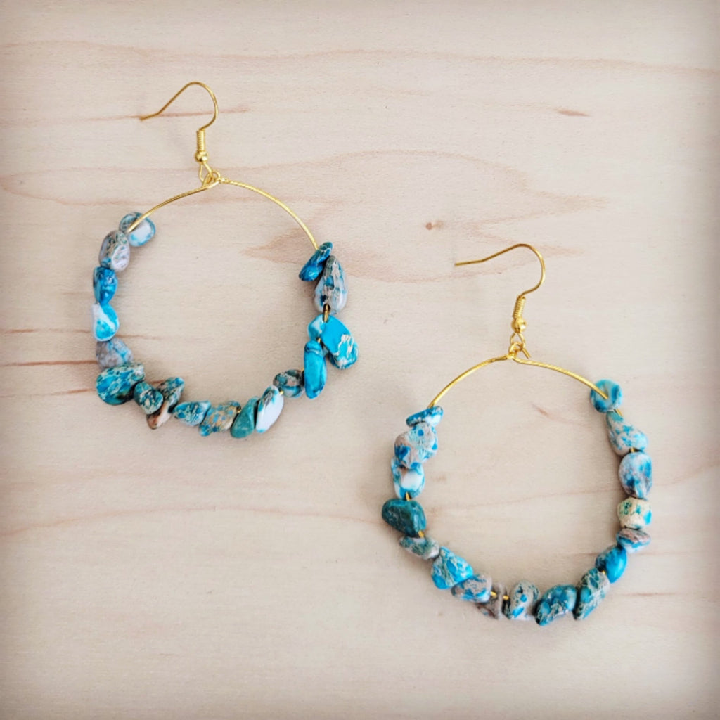 Gold-tone hoop earrings decorated with blue and white tumbled Regalite Jasper gemstone beads.