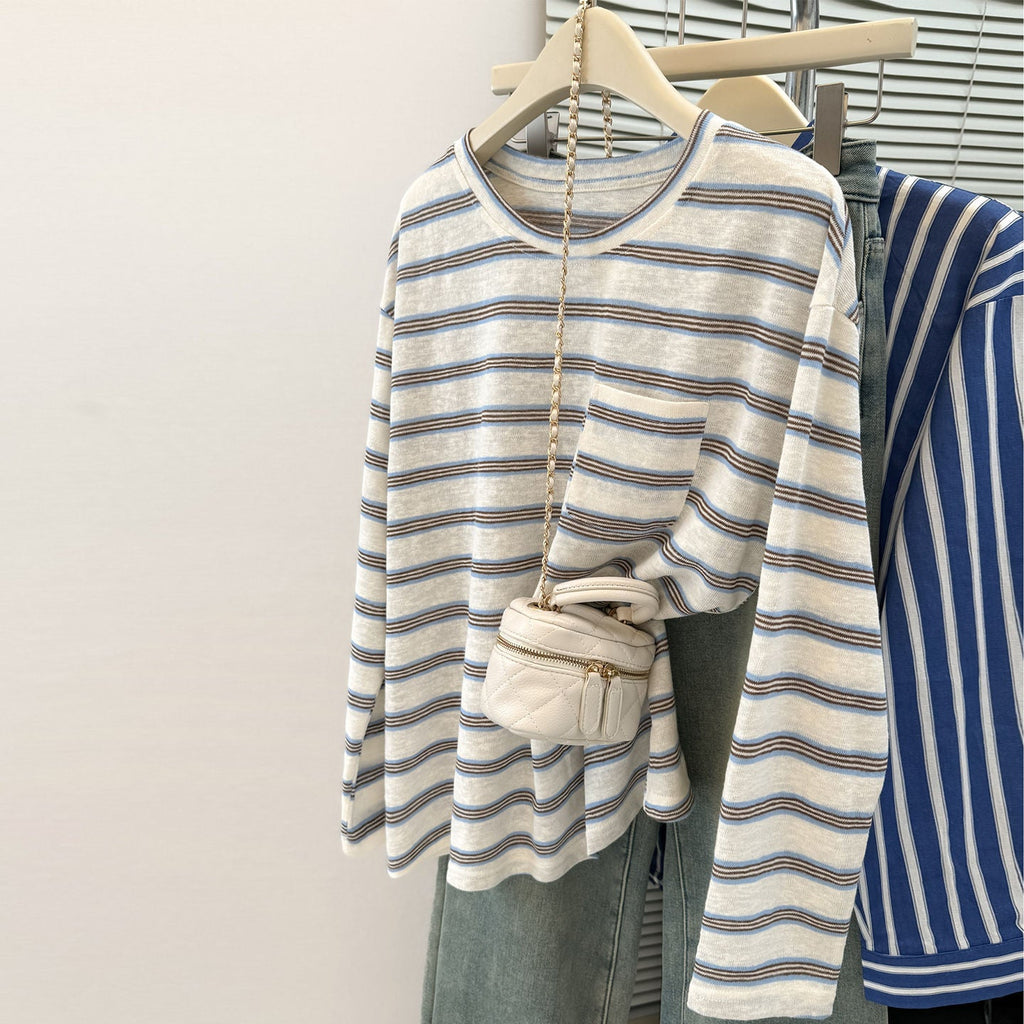 Front and back views of a women's striped long sleeve t-shirt in white with blue and brown stripes, featuring a small chest pocket, displayed on a hanger.