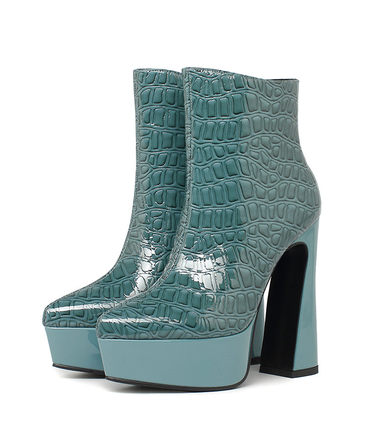 Pair of women's teal patent crocodile embossed platform high heel ankle boots with a chunky block heel on a white background.
