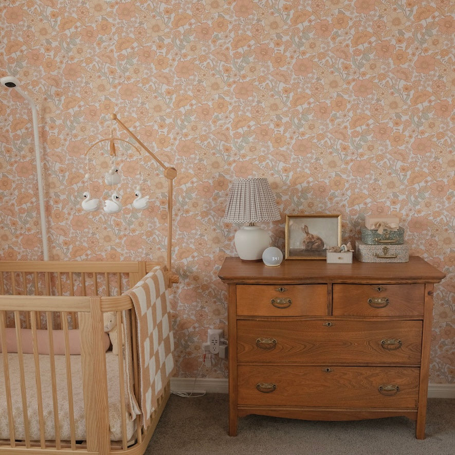 Close up of Heather floral wallpaper featuring a vintage botanical peach and cream pattern in a bedroom setting.