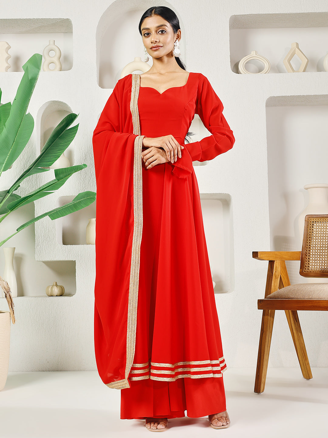 Woman wearing a vibrant red solid Anarkali set with a flared silhouette