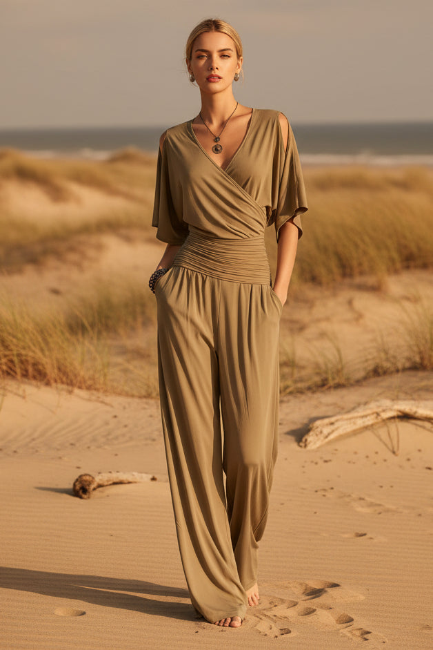 Model wearing a minimalist slim fit V-neck jumpsuit in khaki with a straight leg silhouette