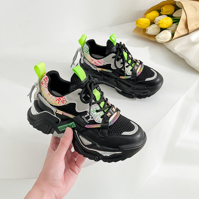 Pair of women's chunky platform fashion sneakers, one white with pink/blue accents and one black with neon green accents, on a clean background.