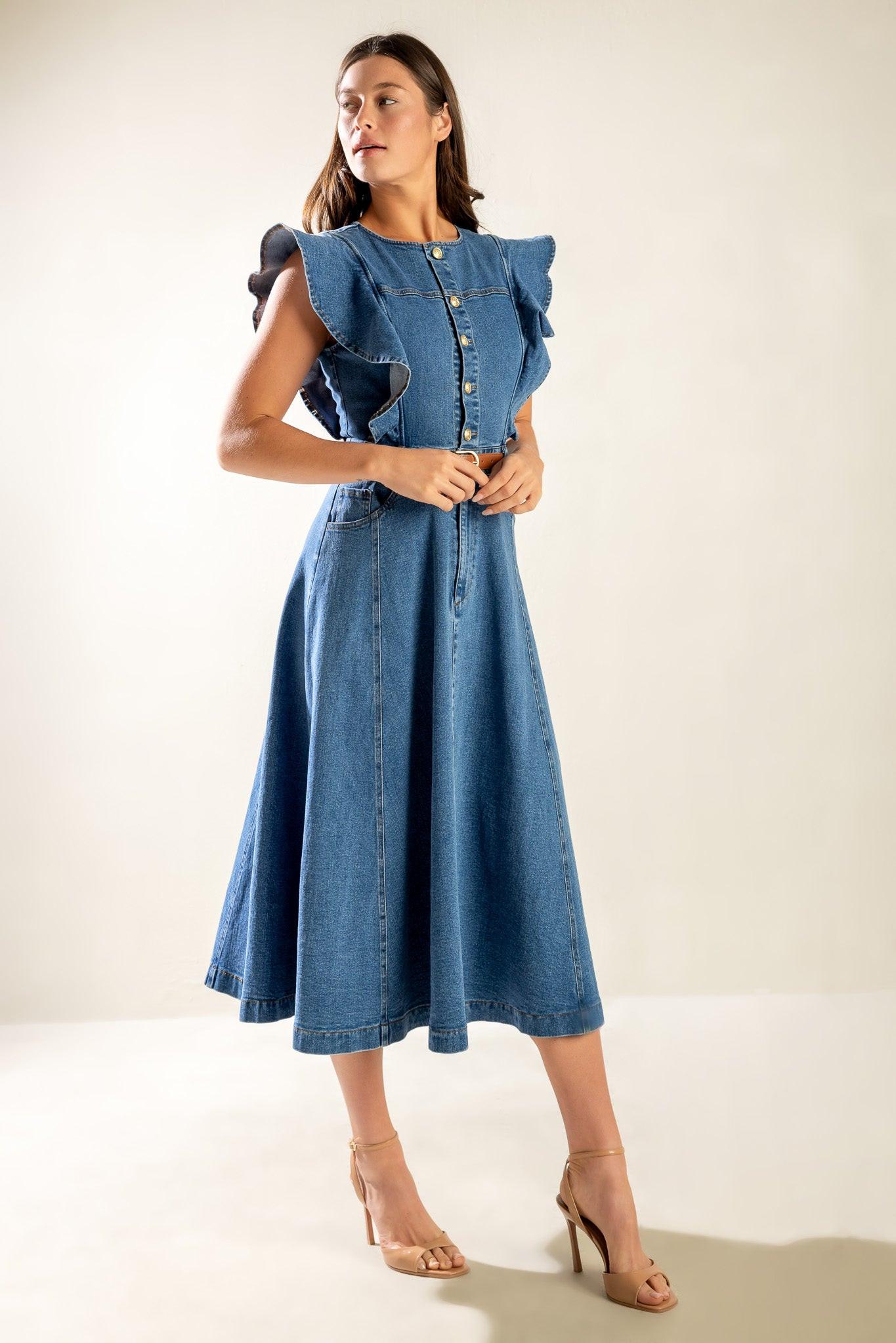 Model wearing a washed blue denim midi dress with ruffled sleeves, front button closure, and a full skirt.