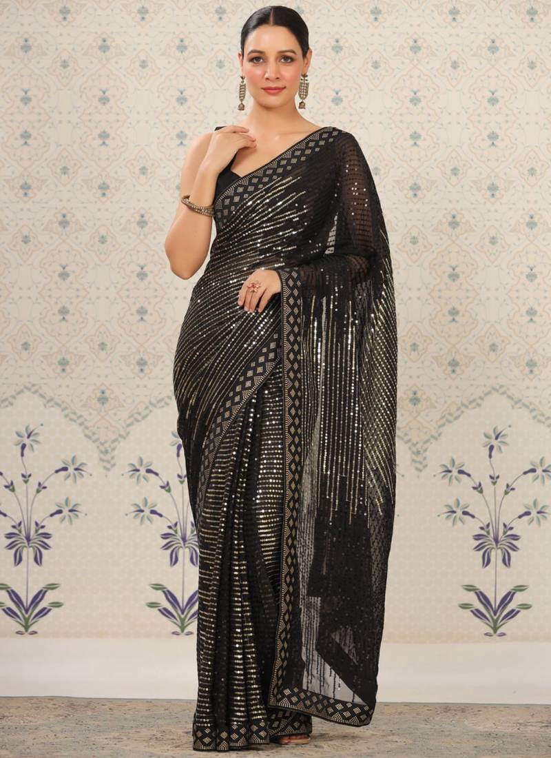 Model wearing a black heavy georgette saree with silver sequin embroidery