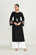 Woman wearing a black rayon tunic with delicate embroidery detailing.