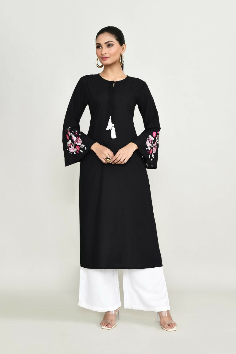 Woman wearing a black rayon tunic with delicate embroidery detailing.