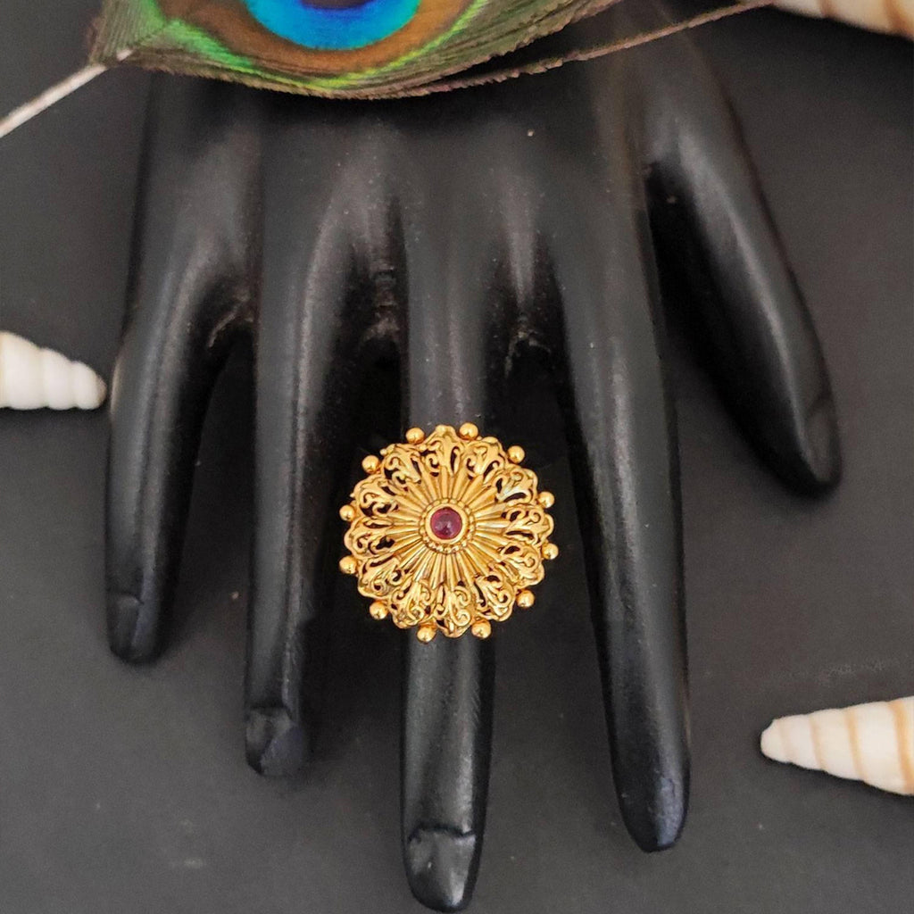 Close-up of designer antique gold polish statement finger ring with filigree detailing