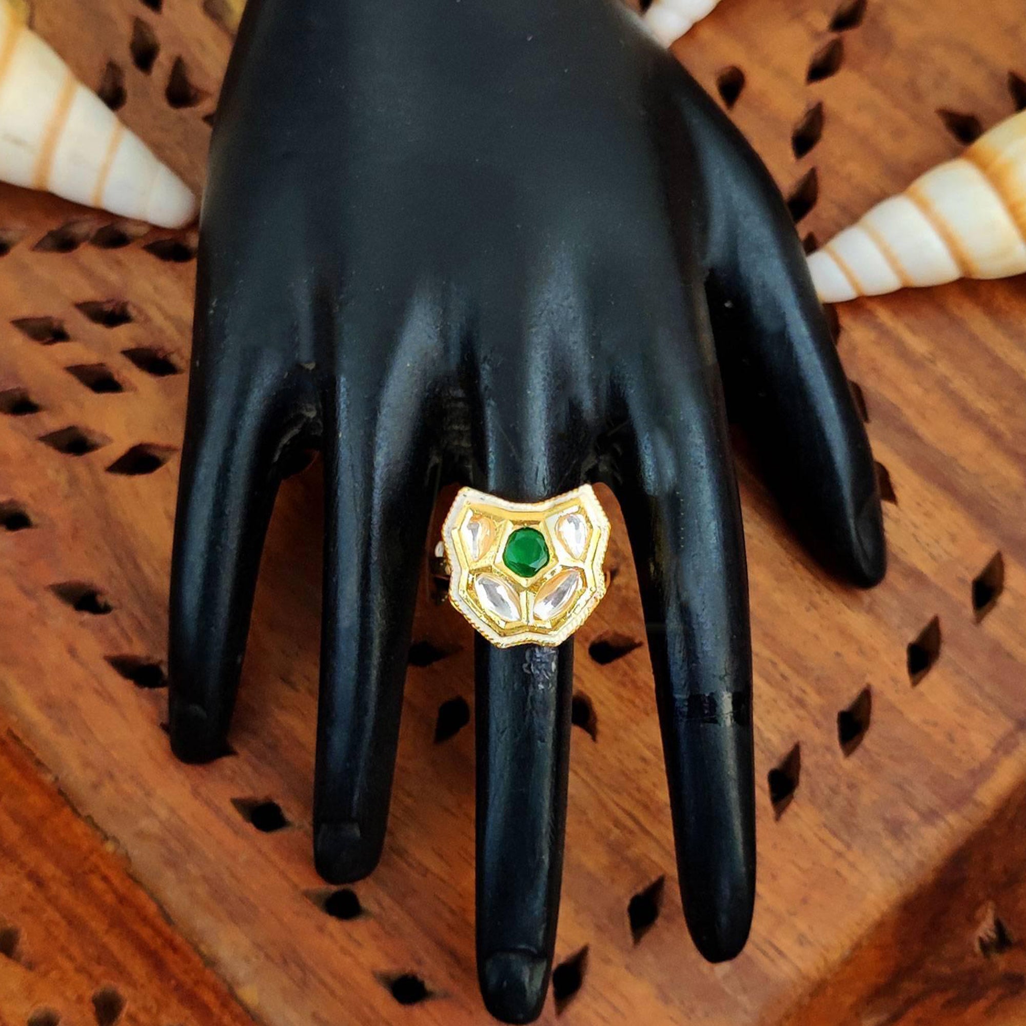 A traditional Kundan finger ring with multi-colored center stones and a polished high gold finish on an adjustable band.