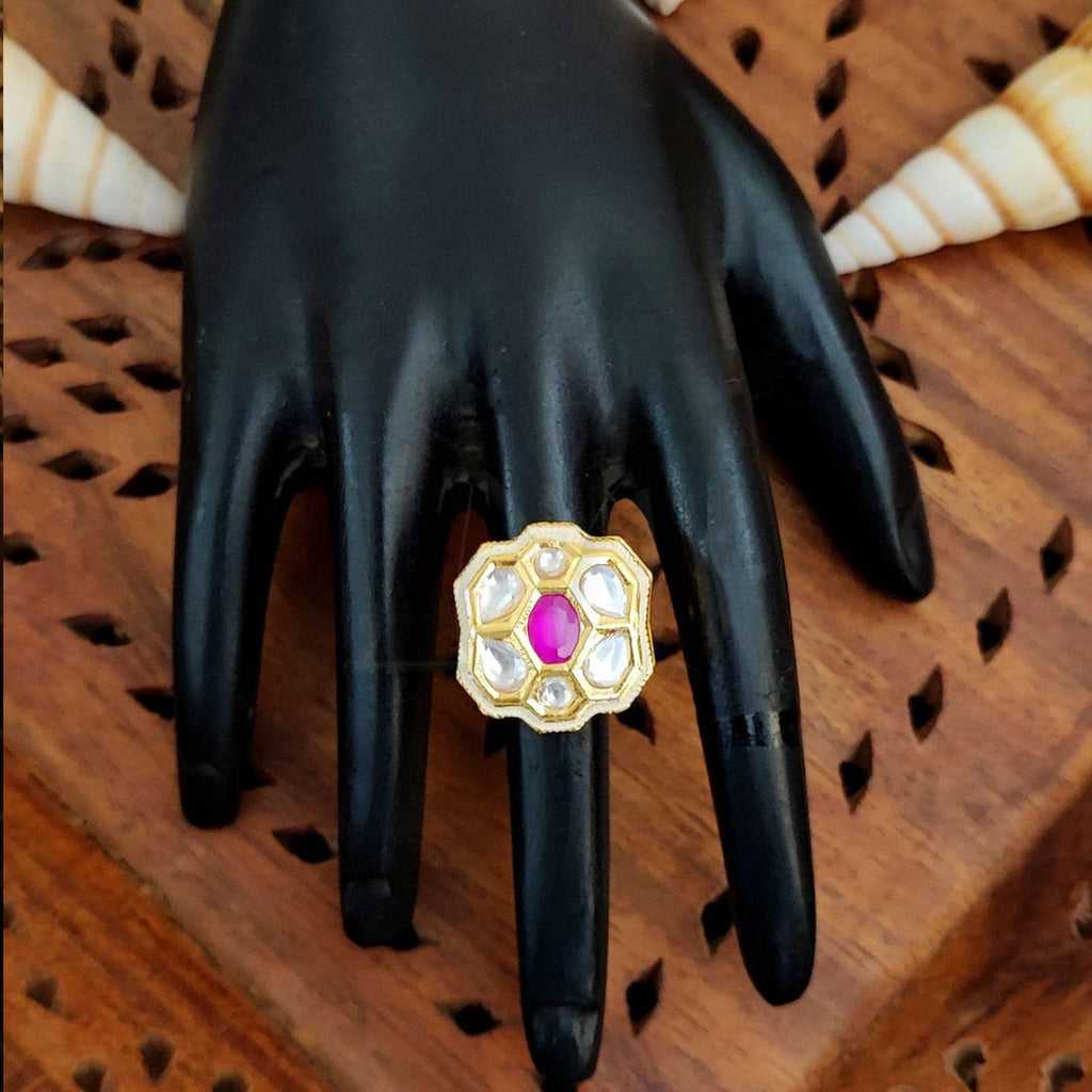 Close-up of a floral Kundan finger ring with multi-colored gemstones and high gold finish on a model hand.