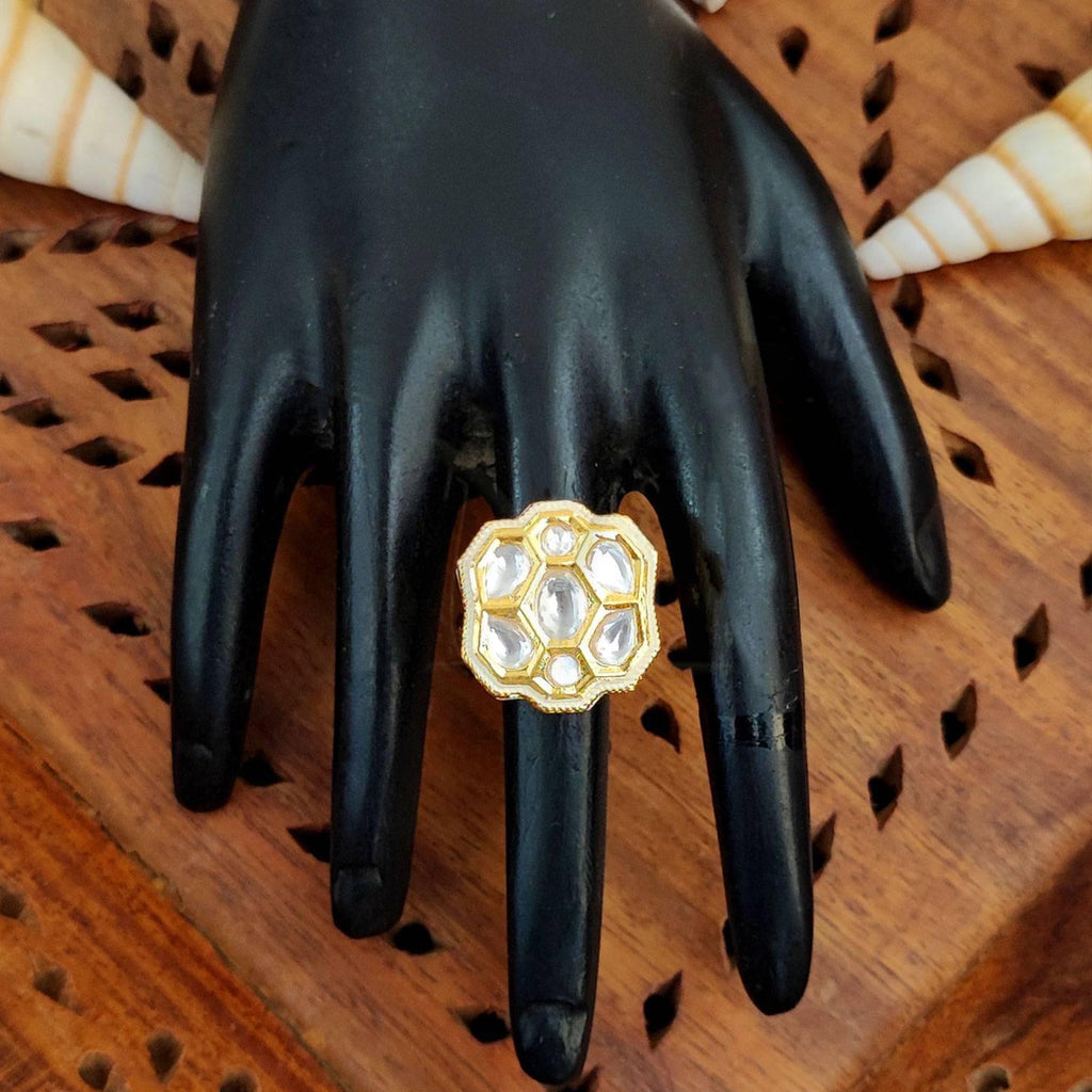 Close-up of a floral Kundan finger ring with multi-colored gemstones and high gold finish on a model hand.