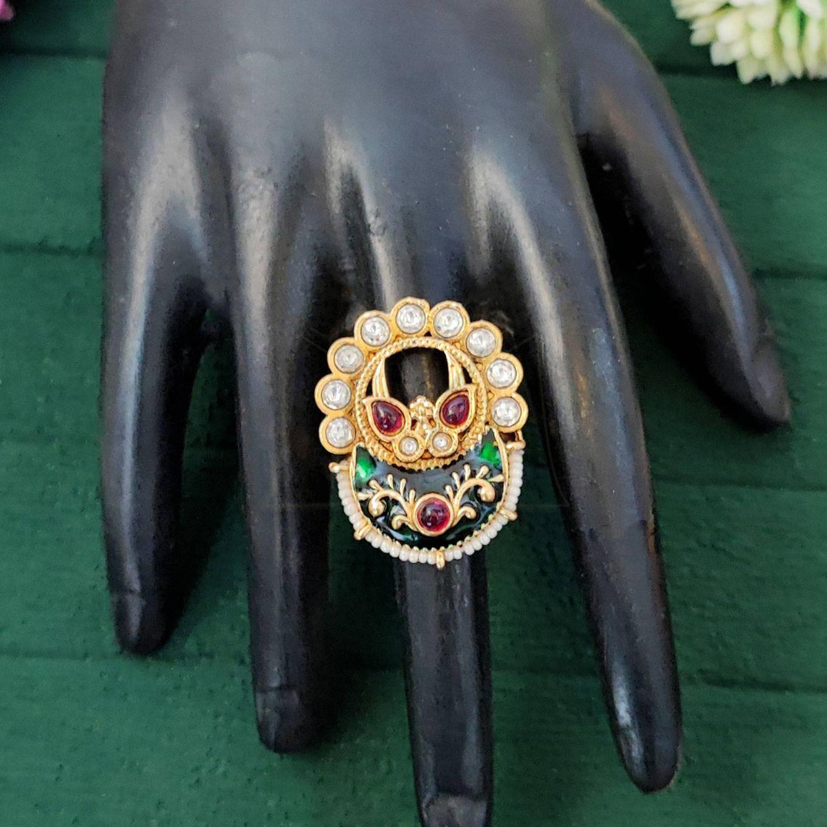 Close-up of designer high gold adjustable finger ring with multicolored gemstones for bridal and festive wear