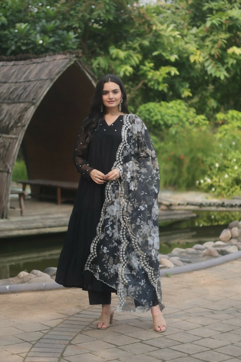 Woman wearing a black A-line faux blooming kurta with butti work, trousers, and matching dupatta
