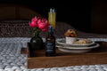 Farmhouse Mornings room spray bottle placed on a rustic wooden tray with a flower vase and pastries.