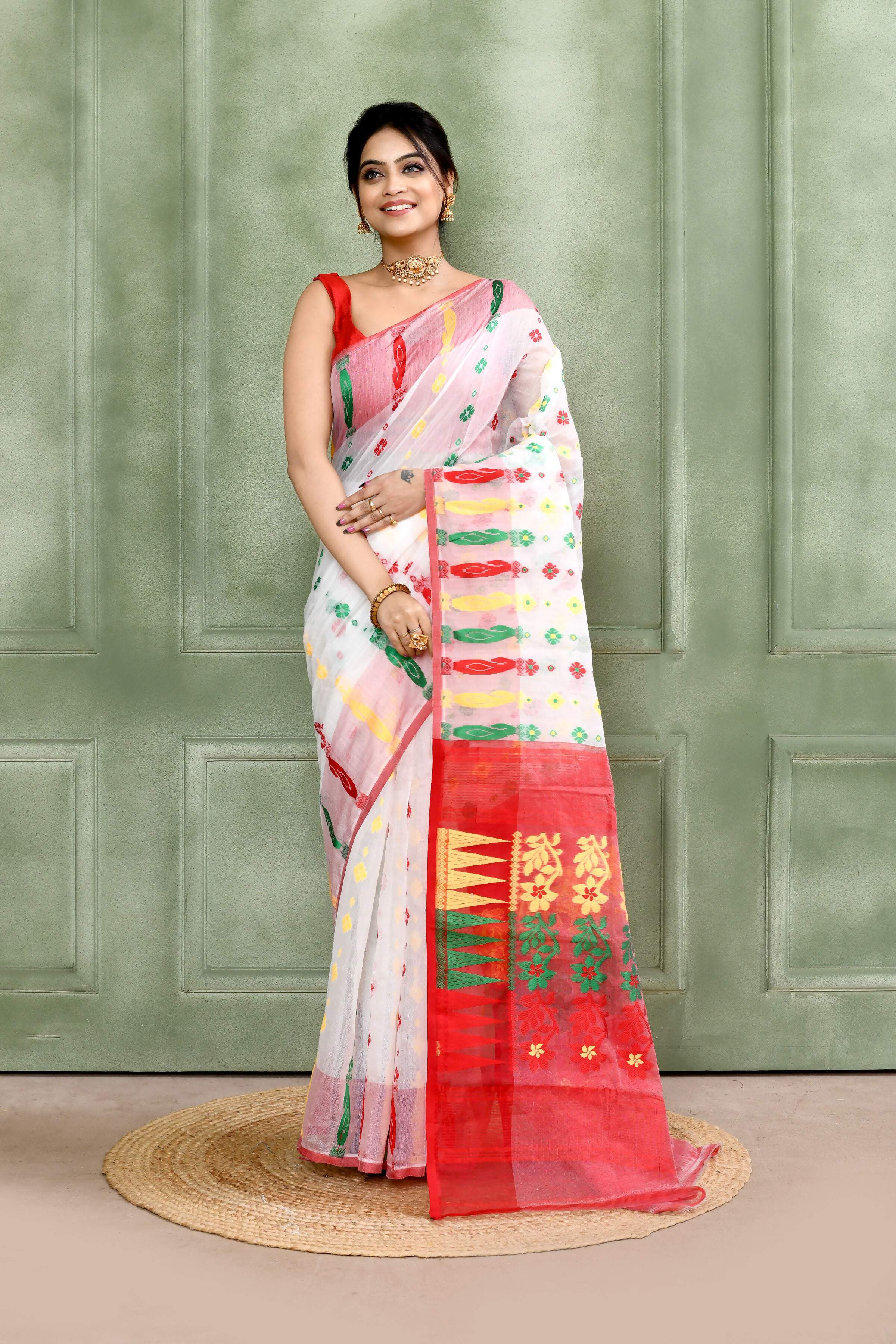 Elegant white embellished cotton blend Jamdani saree draped gracefully for a festive ethnic look.