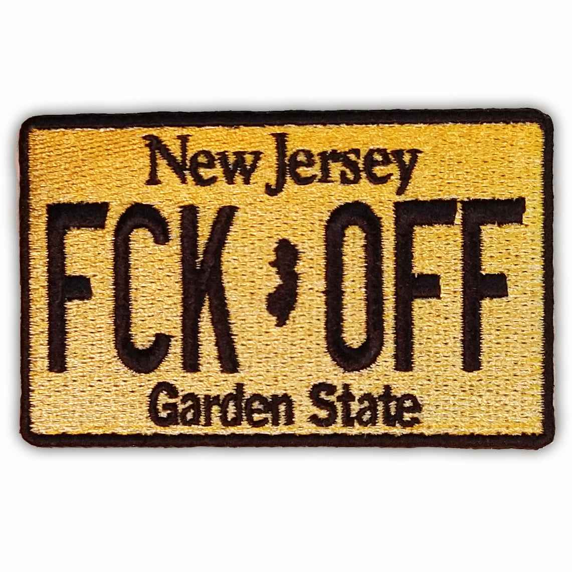 Close up of a rectangular FCK OFF license plate patch with an iron-on backing
