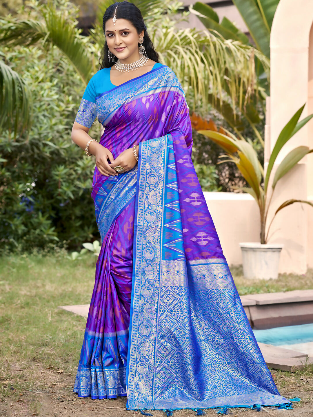 Woman draped in a royal purple Pochampally silk saree with traditional woven details.