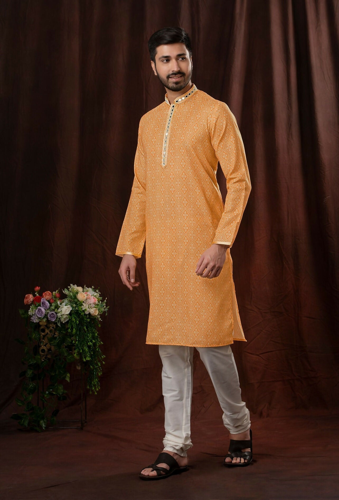 Toddler boy wearing an orange art silk kurta with off-white pyjama trousers