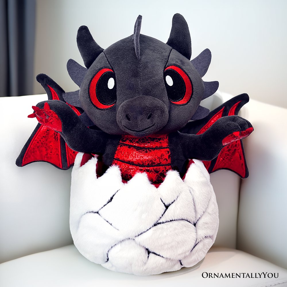 Drogo the Dino 12-inch plushie toy in black and red, shown hatching from a dinosaur egg.