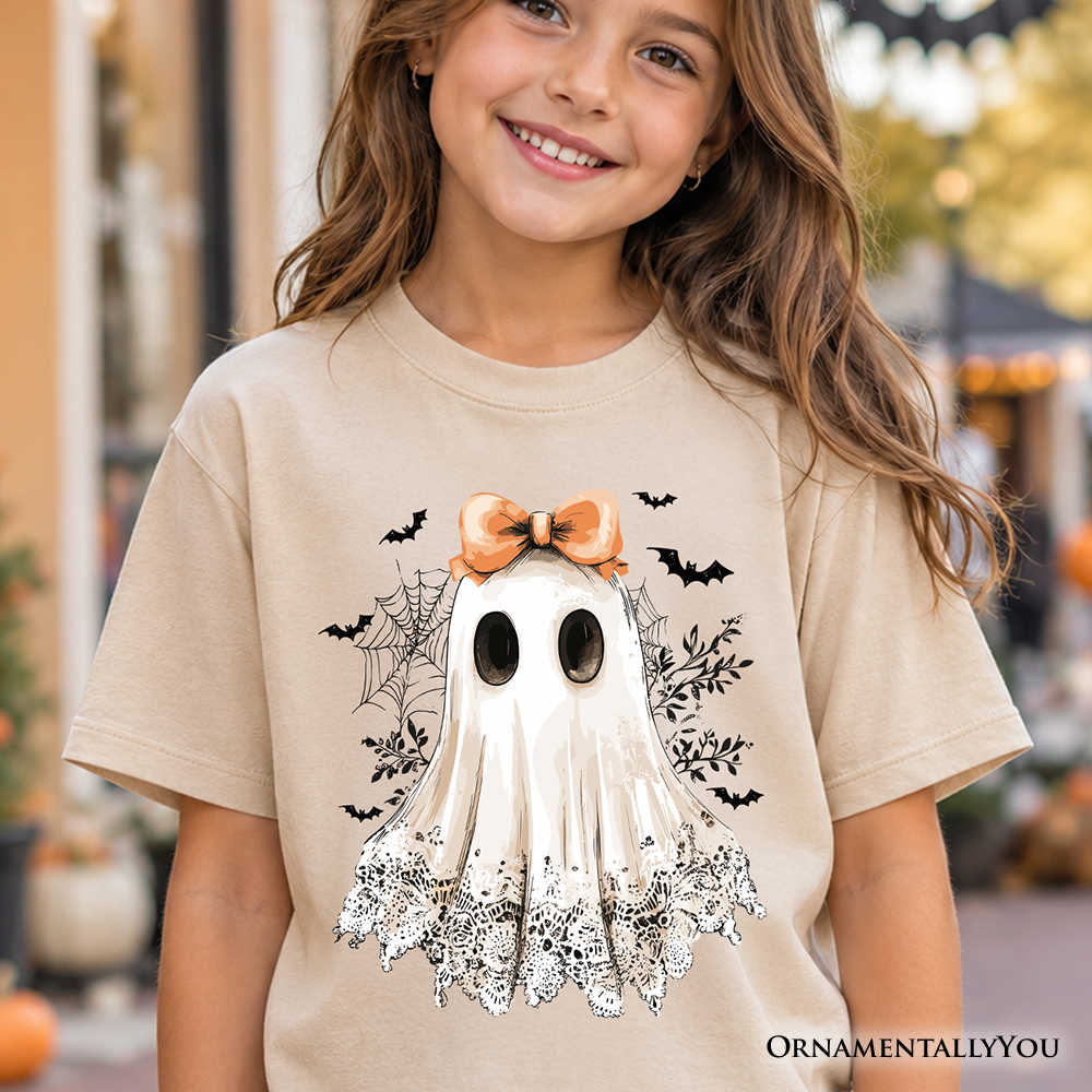 A cute kids Halloween t-shirt featuring a coquette ghost design in white, beige, orange, and black.