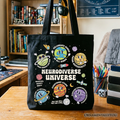Neurodiverse Universe autism awareness graphic on a black and multicolor cotton canvas tote bag.