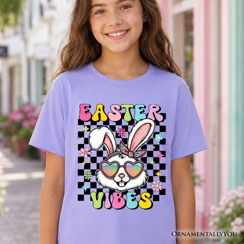 A child wearing a white t-shirt with a retro Easter bunny wearing sunglasses and a checkered pattern graphic.