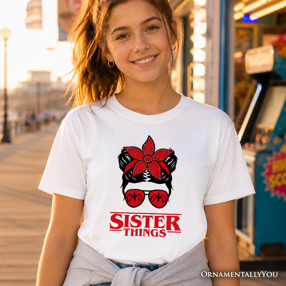 Child wearing a retro style Sister Things t-shirt with a messy bun, red bandana, and glasses graphic design.
