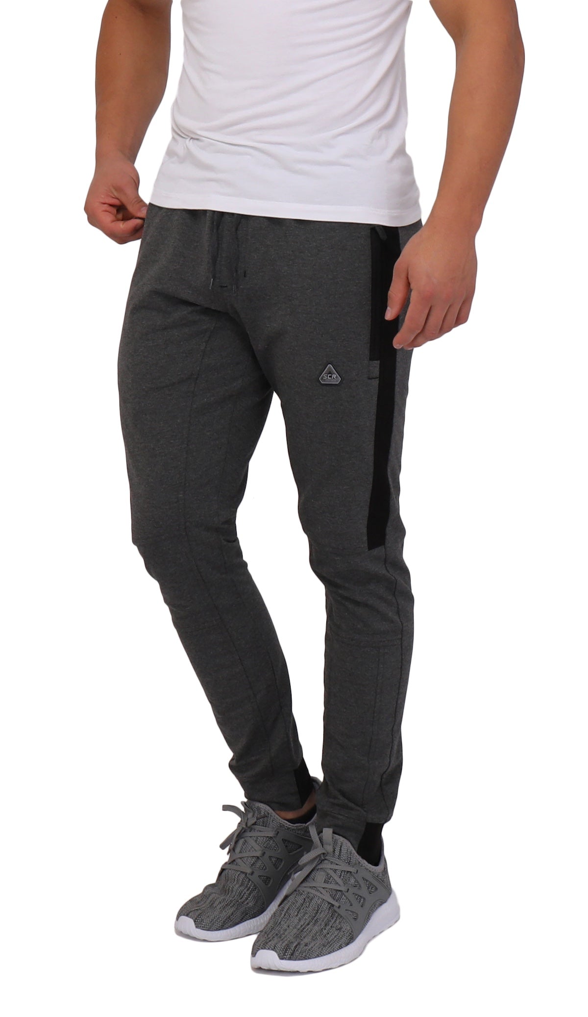 Model wearing dark grey Infinite Flex Tall joggers with black side panel details and zippered pockets.
