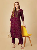 Women wearing a wine-colored straight rayon kurta with intricate paisley embroidery and 3/4 sleeves
