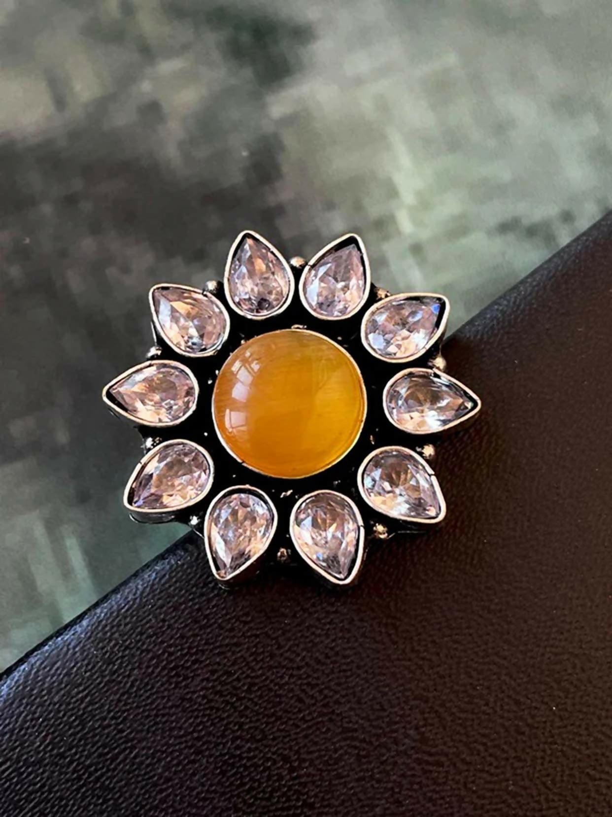 Mustard Monalisa stone brass adjustable ring on a neutral background for luxury jewelry display