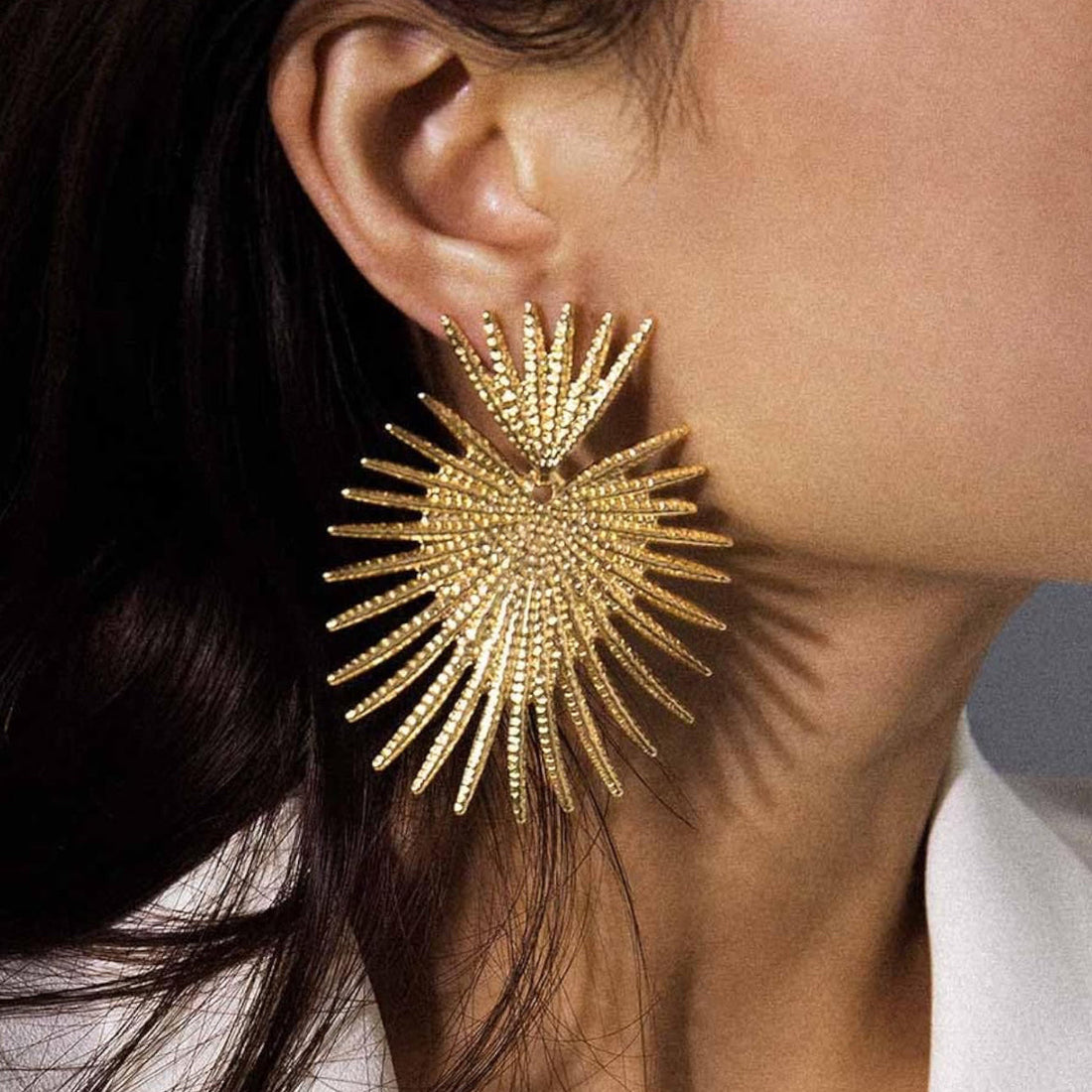 Close up of Gold Starburst Earrings featuring a radiant sunburst design