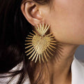 Close up of Gold Starburst Earrings featuring a radiant sunburst design