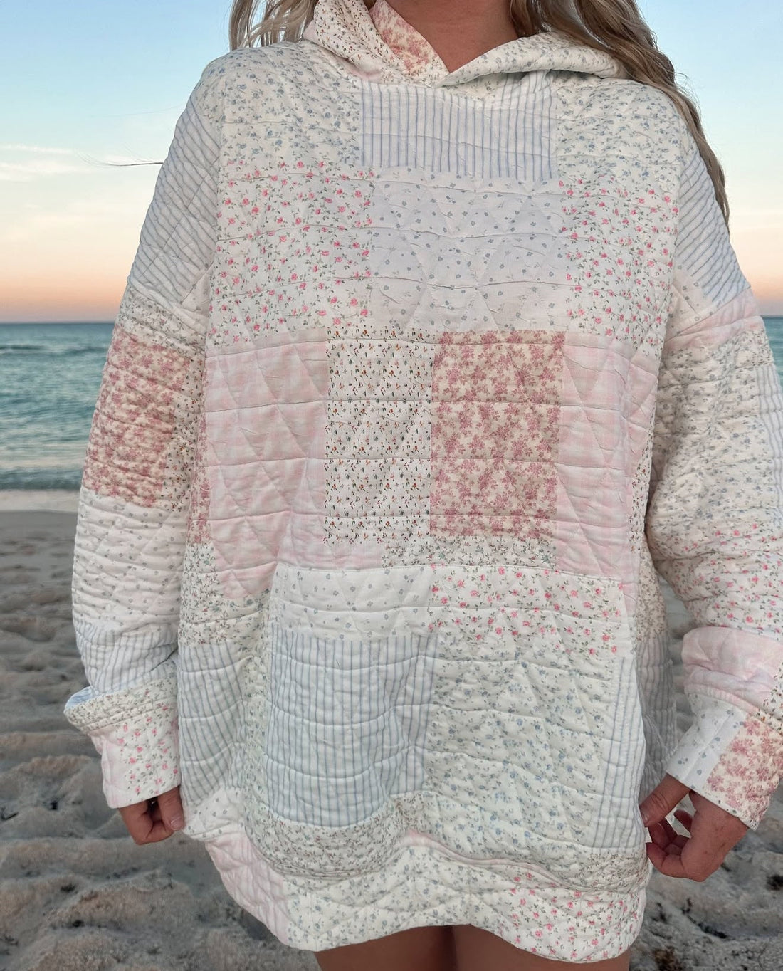 A person wearing a cozy quilted pastel hoodie in a soft, casual aesthetic