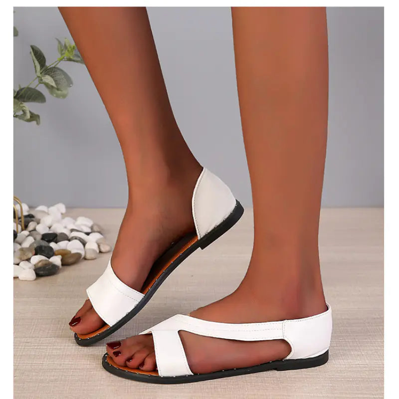 A pair of women's white flat sandals with an open-toe design and a side-strap detail shown from the side and top view.
