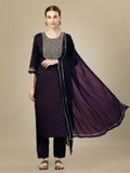 A woman wearing a purple silk blend straight kurta with intricate embroidery and sequence work, styled with matching trousers and a dupatta.