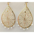 Gold-polished drop earrings featuring white pearl tassels for a formal party look.