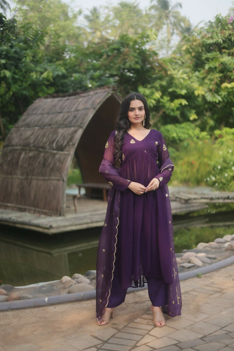 Woman wearing a wine colored A-line faux blooming embroidered kurta with matching trousers and dupatta