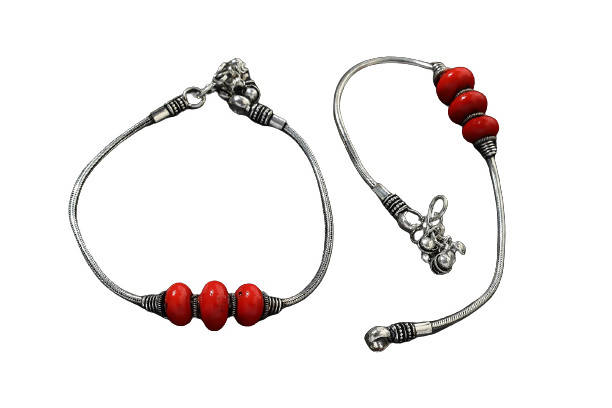 Oxidised silver-tone anklet adorned with vibrant red beads for a traditional look.