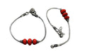 Oxidised silver-tone anklet adorned with vibrant red beads for a traditional look.