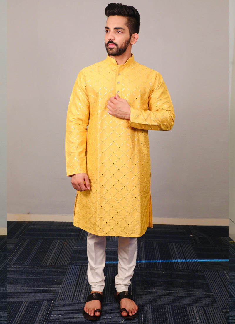 Baby boy wearing a bright yellow silk kurta pajama set with sequence detailing.