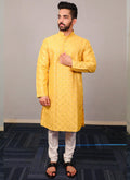 Baby boy wearing a bright yellow silk kurta pajama set with sequence detailing.