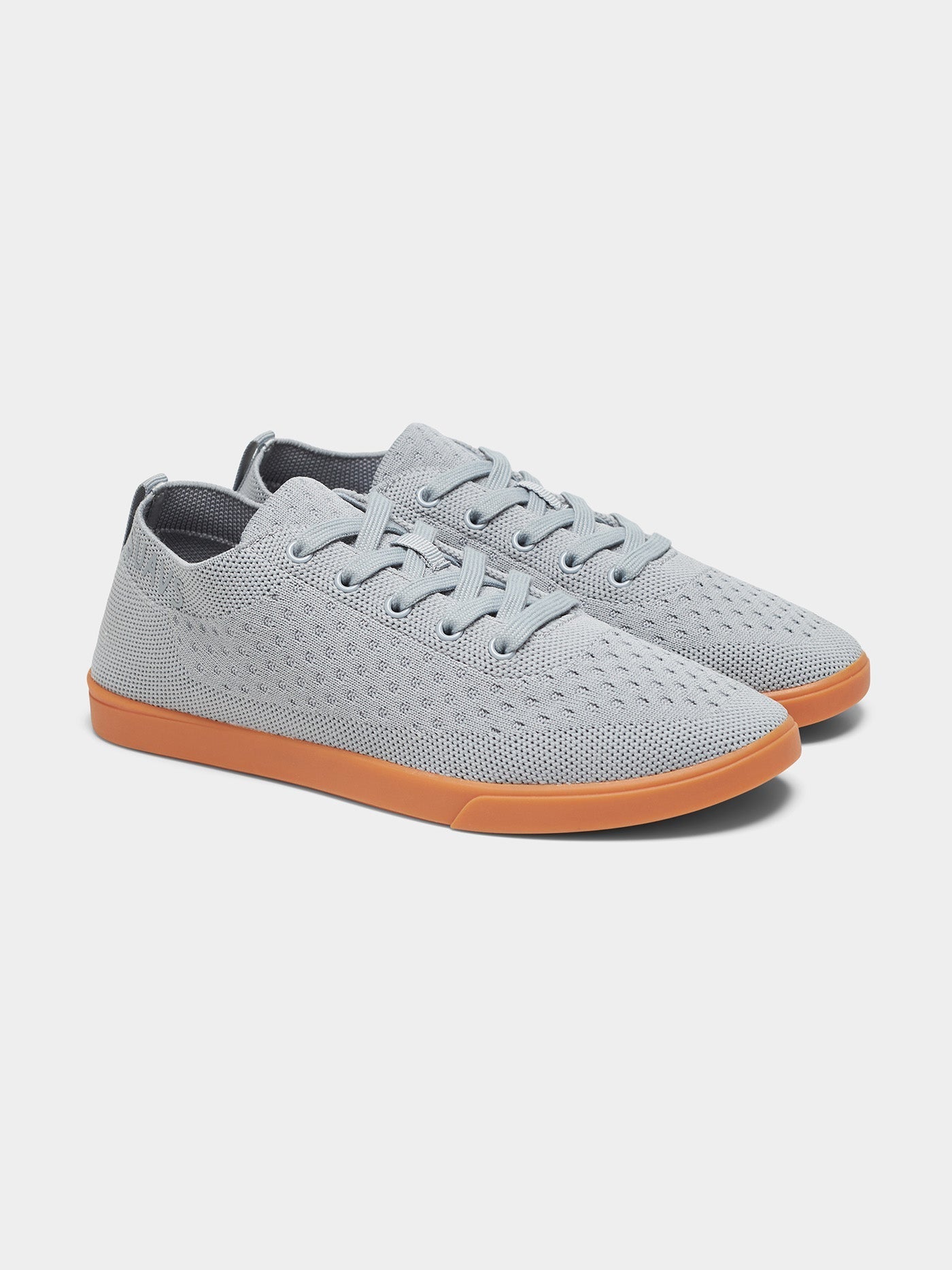 Women's minimalist grey knit sneakers with gum sole in a lifestyle setting
