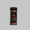 A 3.5oz jar of Game On Seasoning with a black label, red and white typography, resting on a rustic wooden surface.