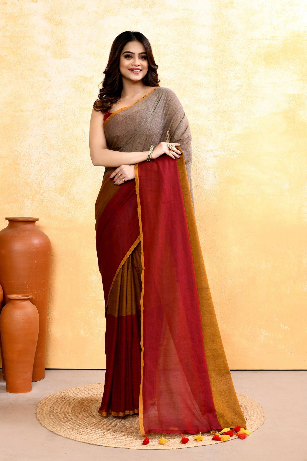 Woman wearing a multi-embellished handloom cotton saree with intricate detailing