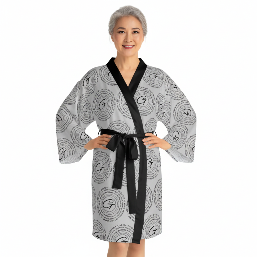 Woman wearing a modern black and gray AOP kimono robe with v-neck and three-quarter bell sleeves.
