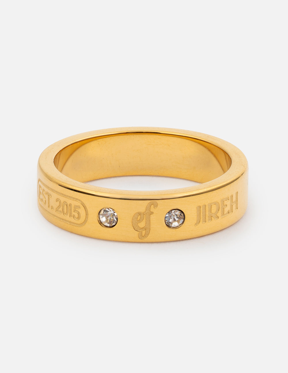 Close up of a bright gold minimalist logo ring featuring a gemstone accent, worn on a finger.