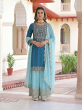 Woman wearing a blue silk embroidered kurti and sharara set with matching dupatta
