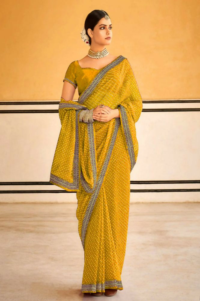 Bright yellow georgette saree with floral embroidery and lace border detail