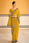 Bright yellow georgette saree with floral embroidery and lace border detail