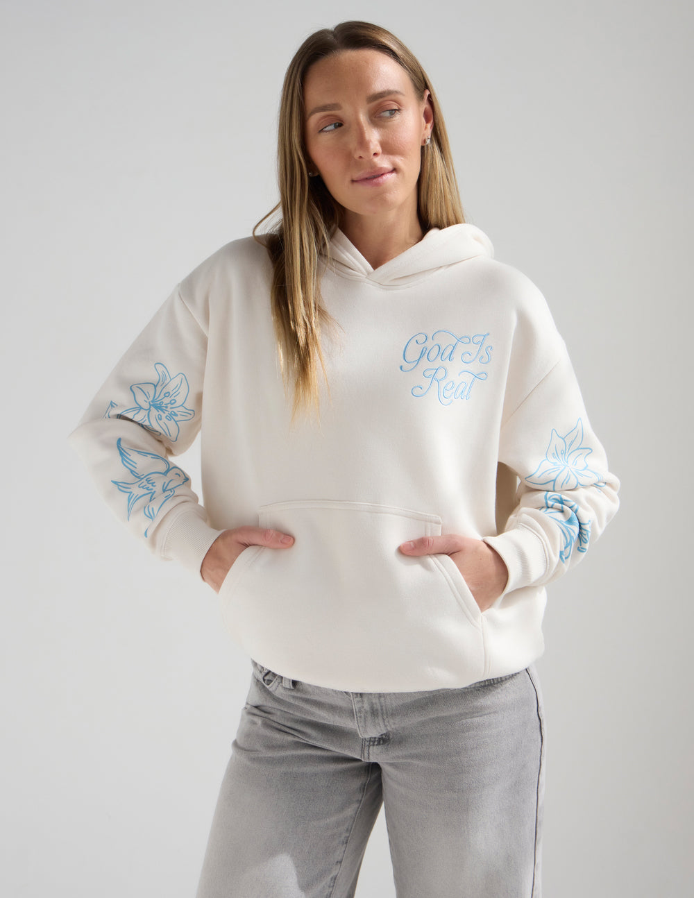 Unisex off-white hoodie with light blue God Is Real Psalm 46:10 graphic print